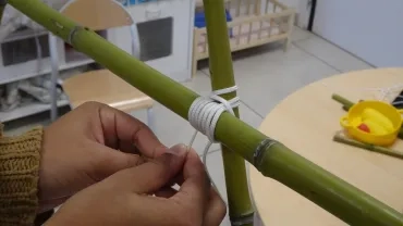 Gros plan sur les mains d'une participante qui fait un noeud de brelage droit