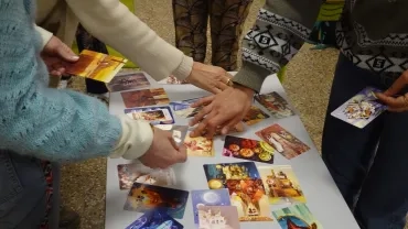 Gros plan sur les mains des adultes participants qui piochent des cartes imagées