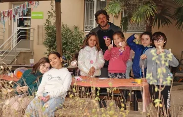 un groupe d'enfants et leur animateur posent avec leurs réalisations