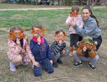 un groupe d'enfants et leur animatrice mettent des masque en feuille sur leur visage