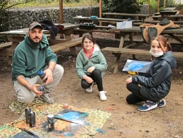 deux enfants et leur animateur montrent leur peintures