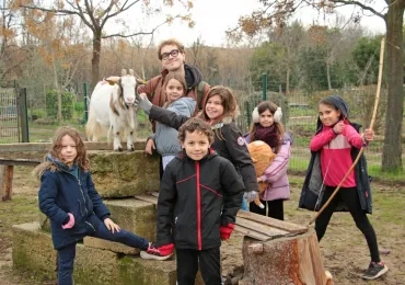 un groupe d'enfants et leur animateur posent avec une chèvre