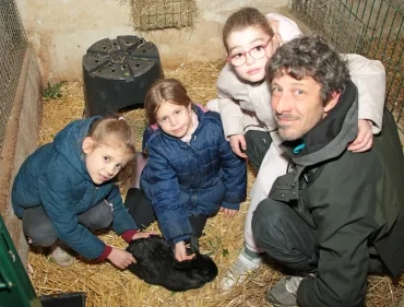 un groupe d'enfants et leur animateur caressent un lapin