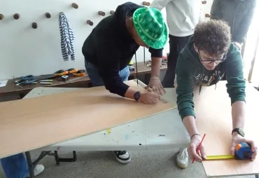 les participants mesures les planches qu'ils vont découper.