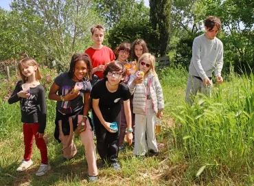 Un groupe d'enfants et leurs animateurs montrent leur récolte