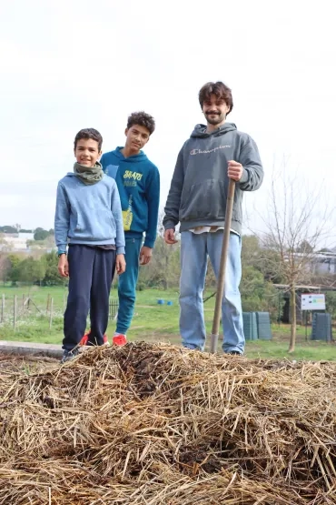 Deux enfants et leur animateur sont en haut d'un tas de paille