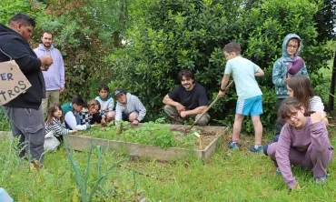 Un groupe d'enfants et leurs animateurs jardinent