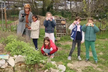 Un groupe d'enfants et leur animatrice prennent des photos