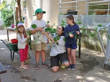 une groupe d'enfants et leur animatrice tiennent une liane