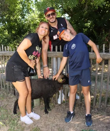 une famille caresse un mouton