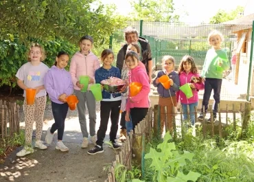 Un groupe d'enfants et leur animateur montrent des carafes
