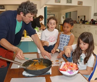 Un groupe d'enfants et leur animateur installent des fleurs sur un sirop