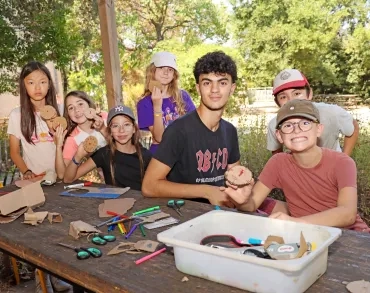 un groupe d'enfants et leur animateur montrent des cercles en carton