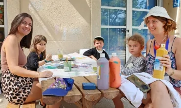 un groupe d'enfants et leurs animatrices peignent