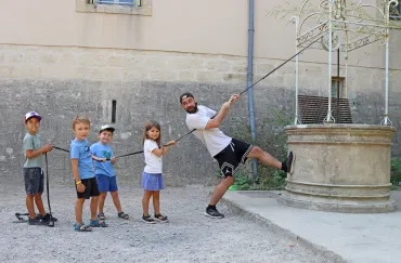 un groupe d'enfants et leur animateur tirent sur une corde