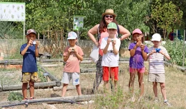 un groupe d'enfants et leur animatrice prennent des photos