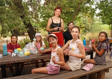 un groupe d'enfants et leur animatrice montrent des piques à brochettes entourées de laine