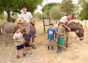 un groupe d'enfants et leurs animateurs posent avec deux ânes