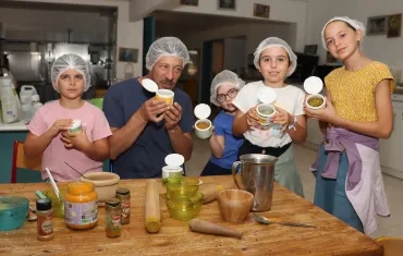 Un groupe d'enfants et leur animateur en cuisine montrent des boîtes de sel
