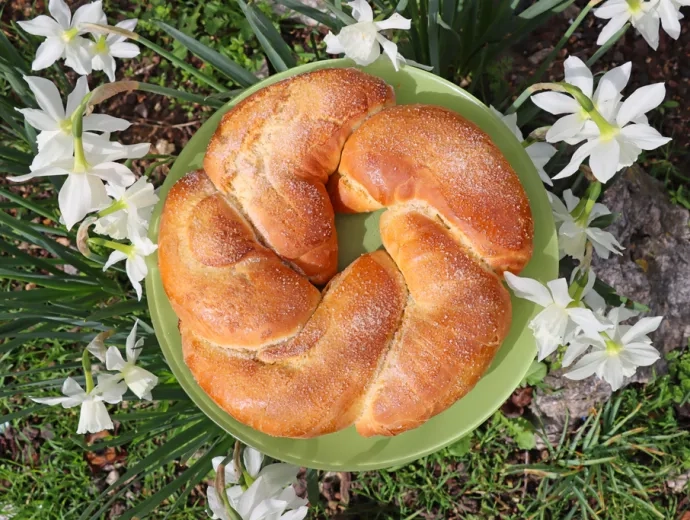 Une brioche posée sur son assiette avec des fleurs autour