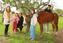 Un groupe d'enfants et leurs animateurs sont à côté d'un cheval