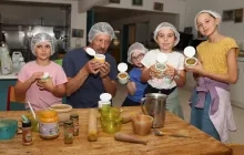 Un groupe d'enfants et leur animateur en cuisine montrent des boîtes de sel